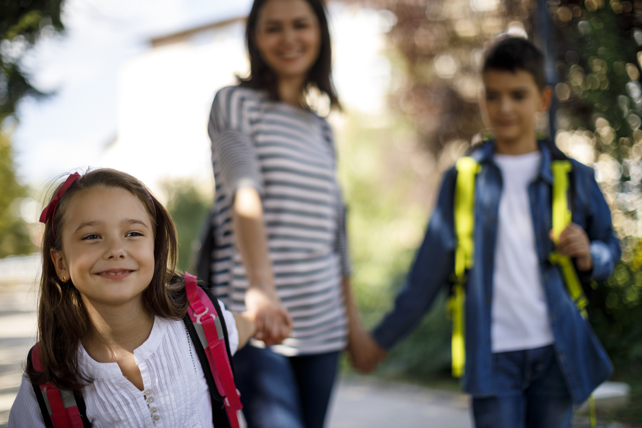 A woman walks her children to school