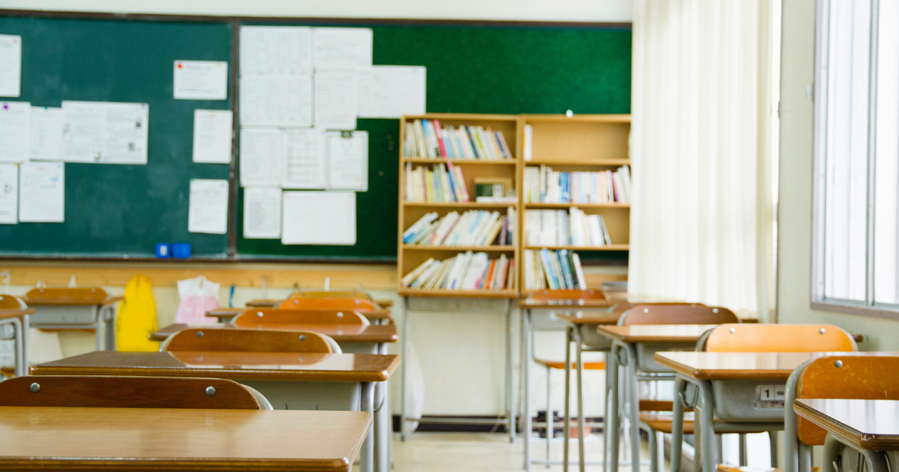 An image of desks in an empty classroom. 