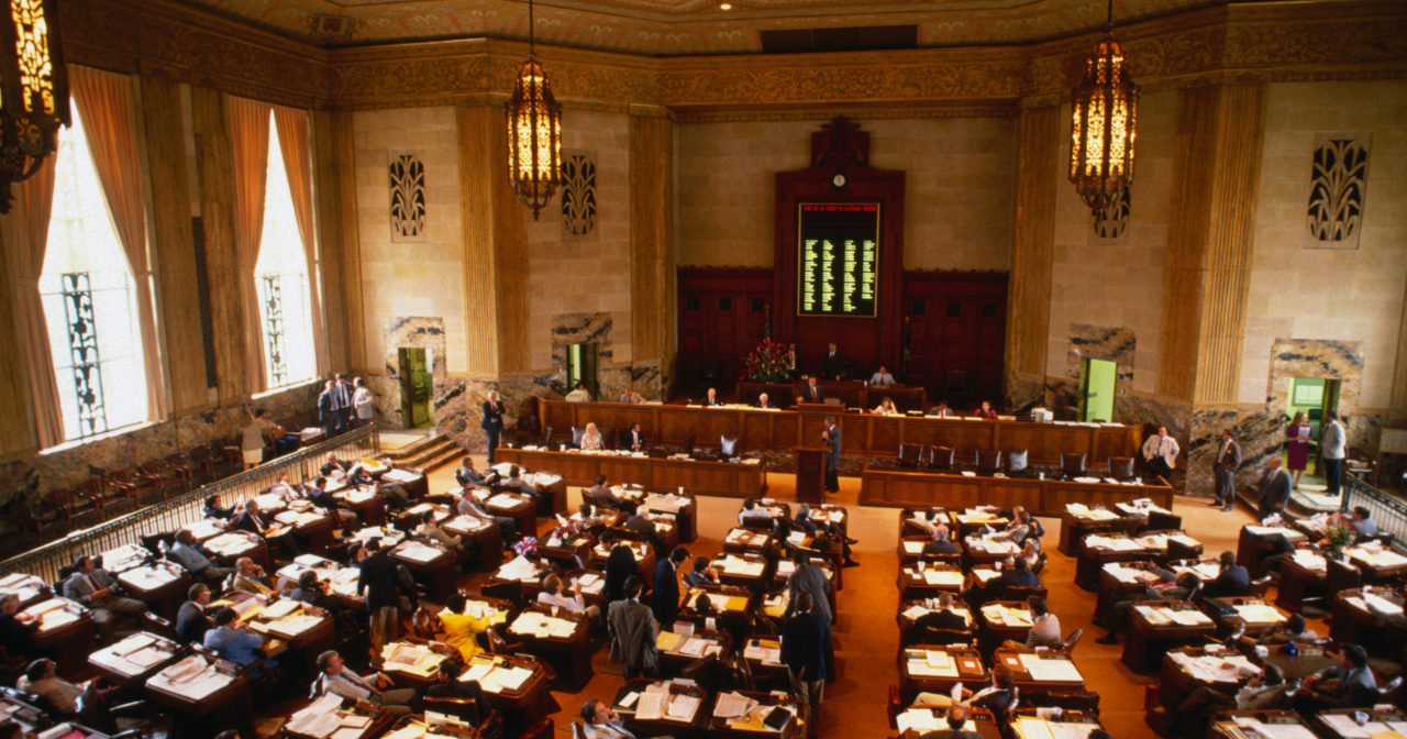 A photo of a state house legislature room not in session. 