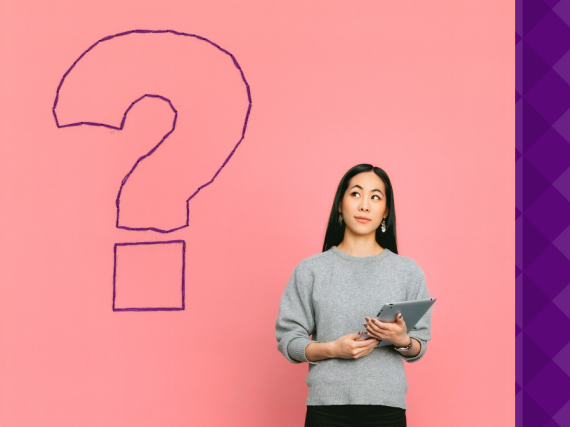 A woman standing next to a giant question mark