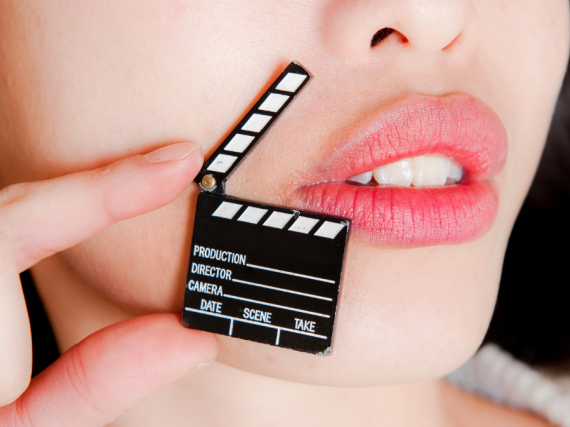 A black and white movie clapper next to a woman's lips