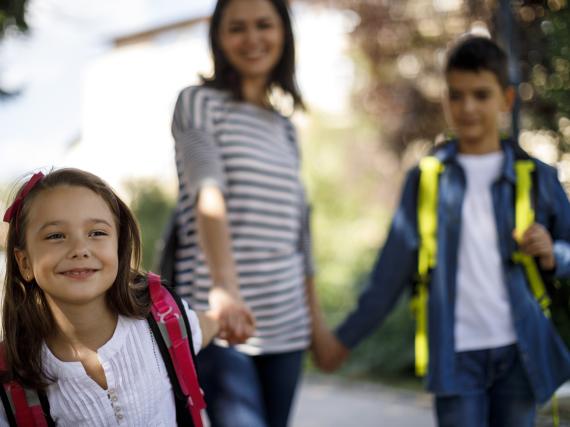 A woman walks her children to school