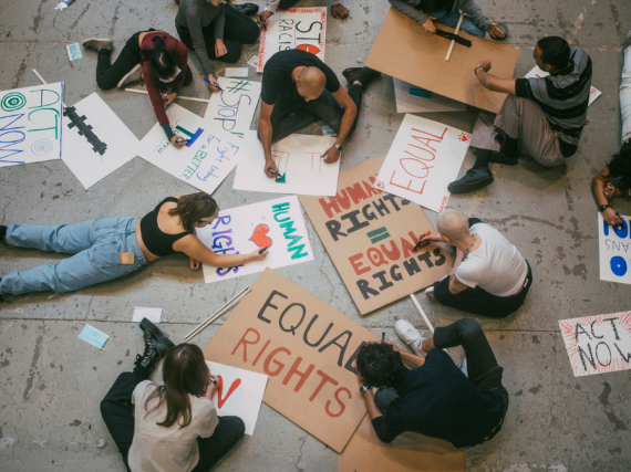 A group of people write out protest signs. 