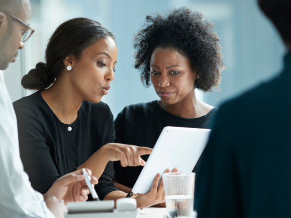 Two Black women work together in a professional setting. 