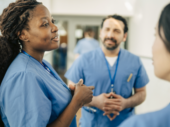 Group of healthcare providers, two women and one man talking.